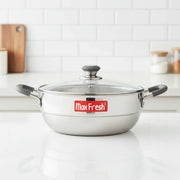 Max Fresh stainless steel multi-kadai with glass lid and black handles on white kitchen counter